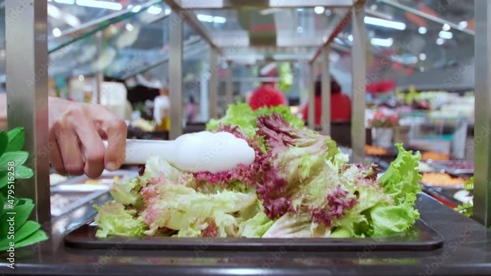Close up women hand use tongs take vegetable from salad bar in supermarket. Close up women hand use tongs take vegetable from salad bar in supermarket.