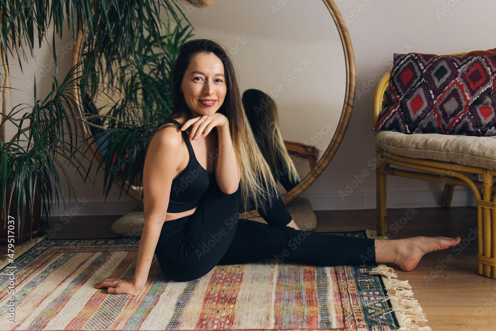 Fototapeta premium Beautiful happy woman sitting on floor posing on camera