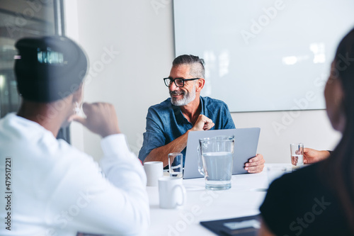 Mature supervisor having a meeting with his team in an office