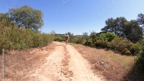 Via de la Plata, a pilgrim walking a dirt road next to Castilblanco de los Arroyos, province of Seville, Andalusia, Spain - dolly forward photo