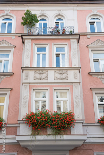 historic house facade munich, with balcony, jutties and geranium flowers