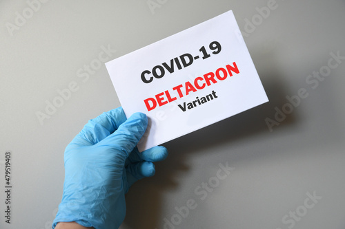Doctor's hand in blue glove with white paper and text Deltacron Variant. Concept of medical variety Deltacron Variant and COVID-19. COVID-19 Deltacron Variant concept.