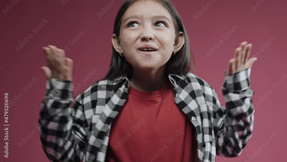 Portrait of little girl giving surprised and happy emotions on a pink background. Cute kid standing in the studio with pink background. High quality 4k footage Portrait of little girl giving surprised and happy emotions on a pink background. Cute kid standing in the studio with pink background. High quality 4k footage