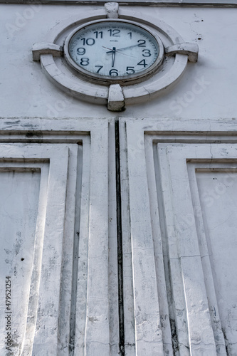 vintage and retro public city clock showing the time on the white wall ornament with low angle view
