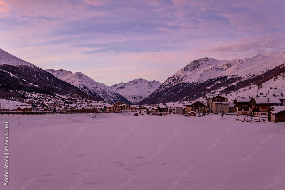 Obraz premium The Italian ski resort town of Livigno at sunrise with traditional alpine buildings