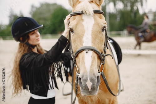 Portrait of riding horse with woman in black helmet © hetmanstock2