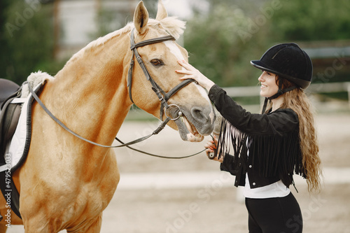 Portrait of riding horse with woman in black helmet with comb © hetmanstock2