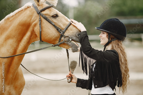 Portrait of riding horse with woman in black helmet with comb © hetmanstock2
