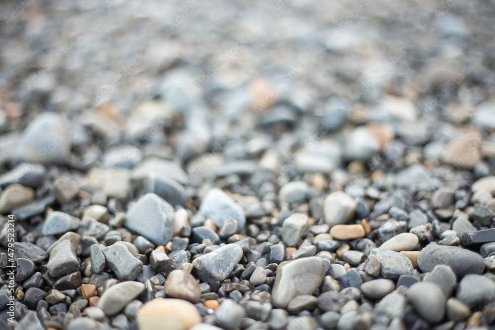 background of wet pebbles, selective focus, back part out of focus. grey and brown tones. stones from the seashore. background of wet pebbles, selective focus, back part out of focus. grey and brown tones. stones from the seashore.