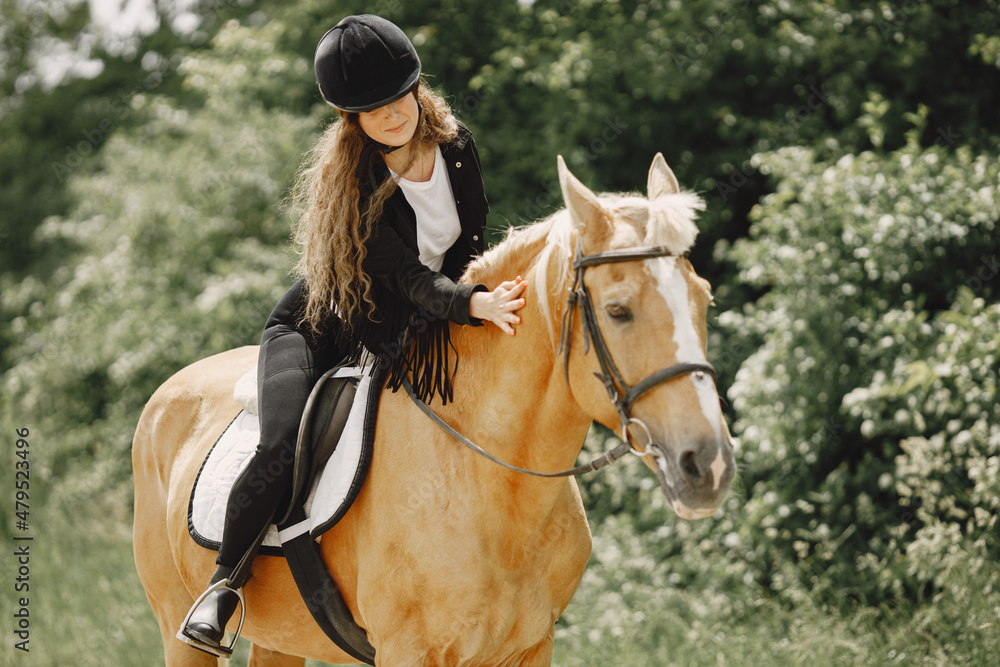 Obraz premium Portrait of woman in black helmet riding a brown horse