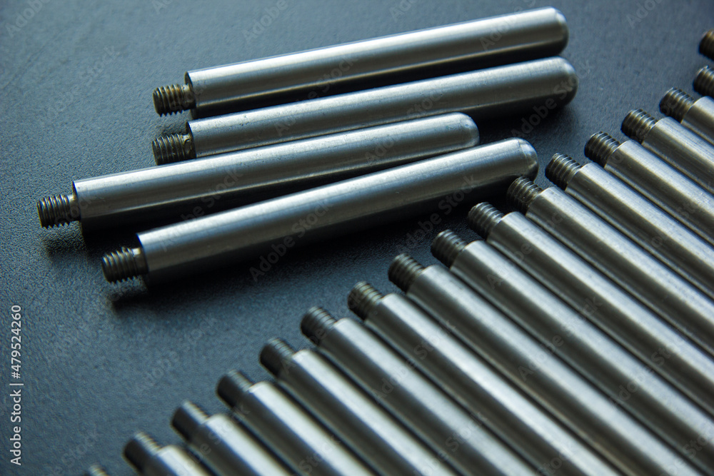 Rod, axis with thread on the table. Parts in a row at the factory. Rod, axis with thread on the table. Parts in a row at the factory.
