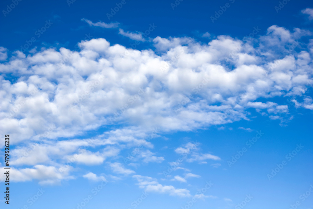 Naklejka premium A strip of aerial volumetric clouds in clear weather against a blue sky.