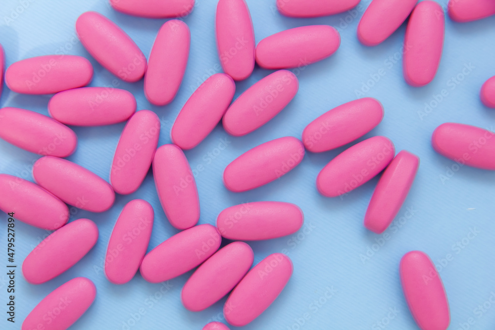 Background of pharmaceutical medicament, cure in container for health on blue background. Vitamin pills