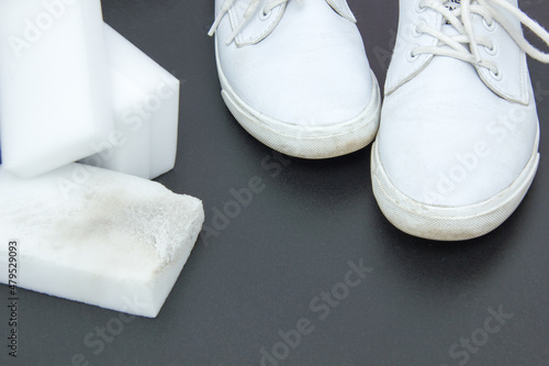 Melamine sponge and white sneakers on a bright background. Purity concept