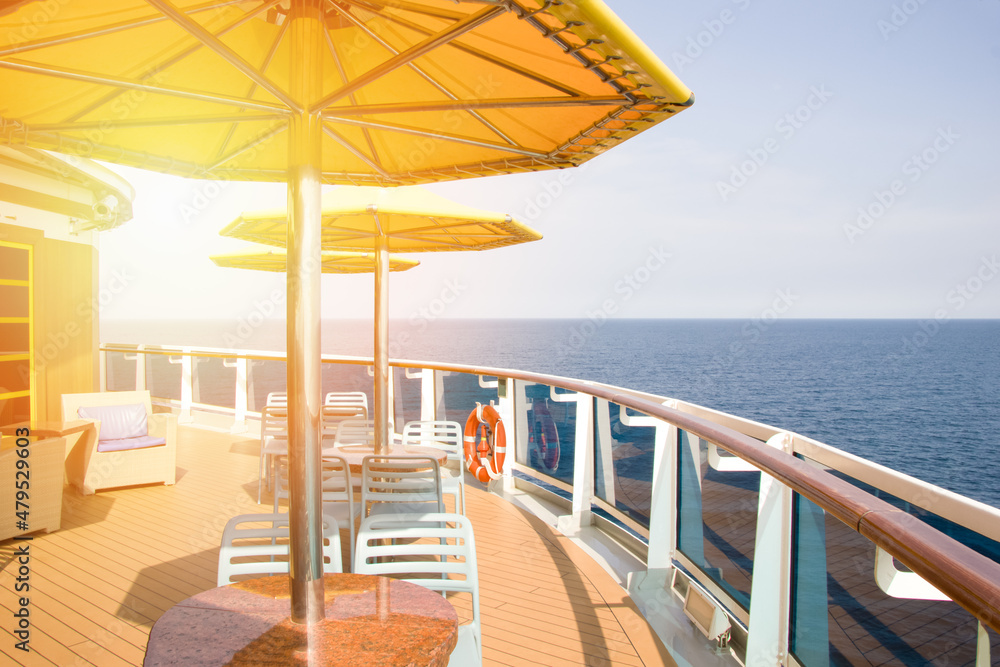 The liner in the open ocean, a place to relax, tables and umbrellas on the deck. Ship resting place
