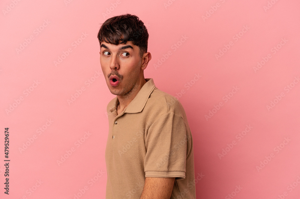 Young mixed race man isolated on pink background looks aside smiling, cheerful and pleasant. Young mixed race man isolated on pink background looks aside smiling, cheerful and pleasant.