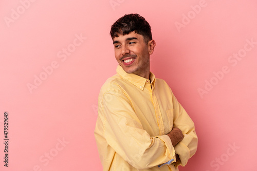 Young mixed race man isolated on pink background laughing and having fun.