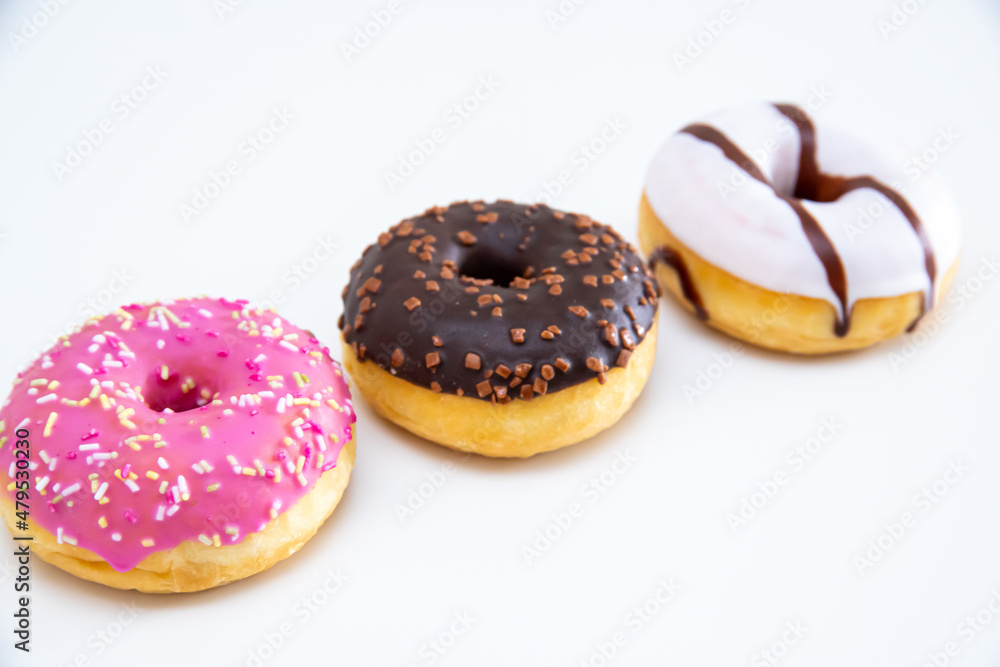 Close up of three different kind of donuts on white background. Close up of three different kind of donuts on white background.
