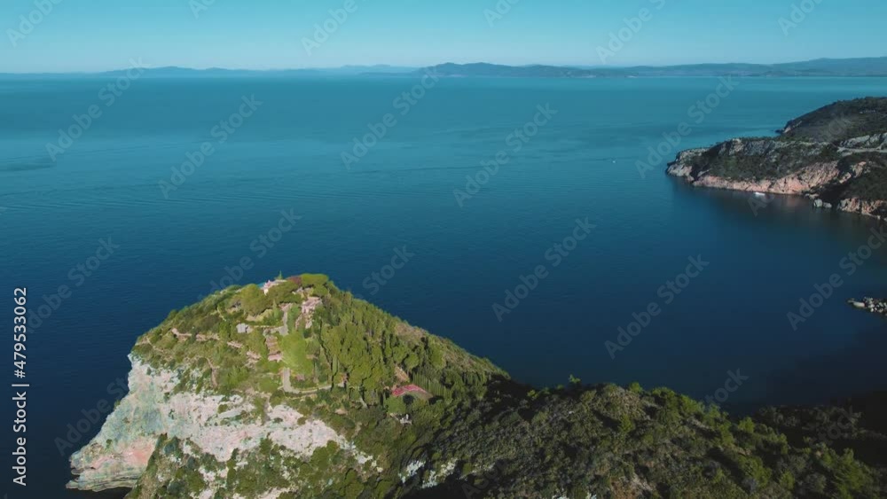 Clear blue turquoise and calm seaside water at a natural sand beach coast bay at Monte Argentario, Italy. 4K UHD aerial drone air flight at scenic tourist holiday destination on nature vacation island Clear blue turquoise and calm seaside water at a natural sand beach coast bay at Monte Argentario, Italy. 4K UHD aerial drone air flight at scenic tourist holiday destination on nature vacation island