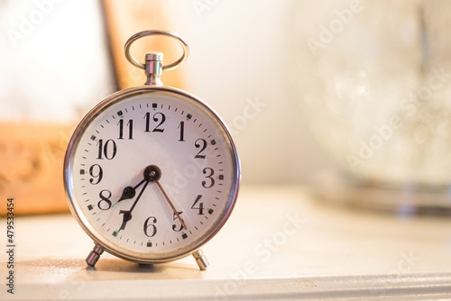 vintage alarm clock on table with soft background evening light 
