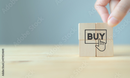 E-commerce or online shopping concept. Conversion, customer behavior. Put wooden cubes with hand finger clicking cursor for buy or register design on grey background and copy space. Marketing banner.