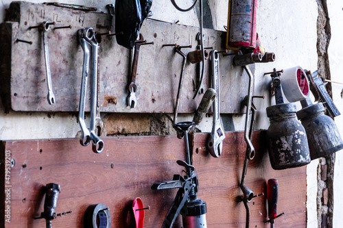 various garage tools for a workshop for auto service and car repair hangs on the wood wall