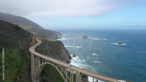 Vehicles Driving At Bixby Creek Bridge With Seascape Views In Big Sur, Monterey, California. - aerial descend