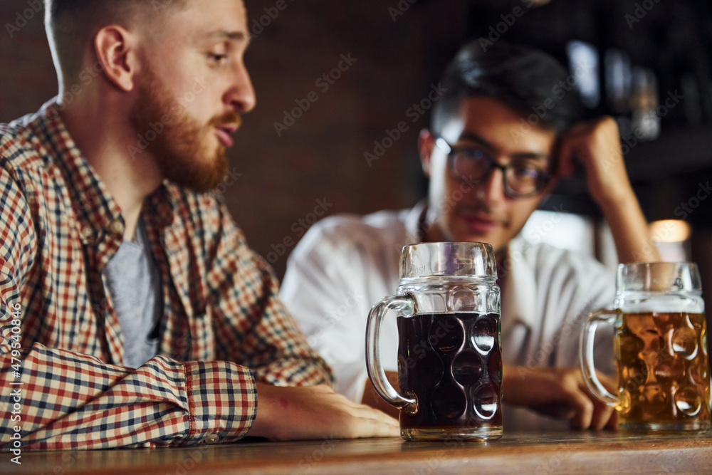 People in casual clothes sitting in the pub and having conversation