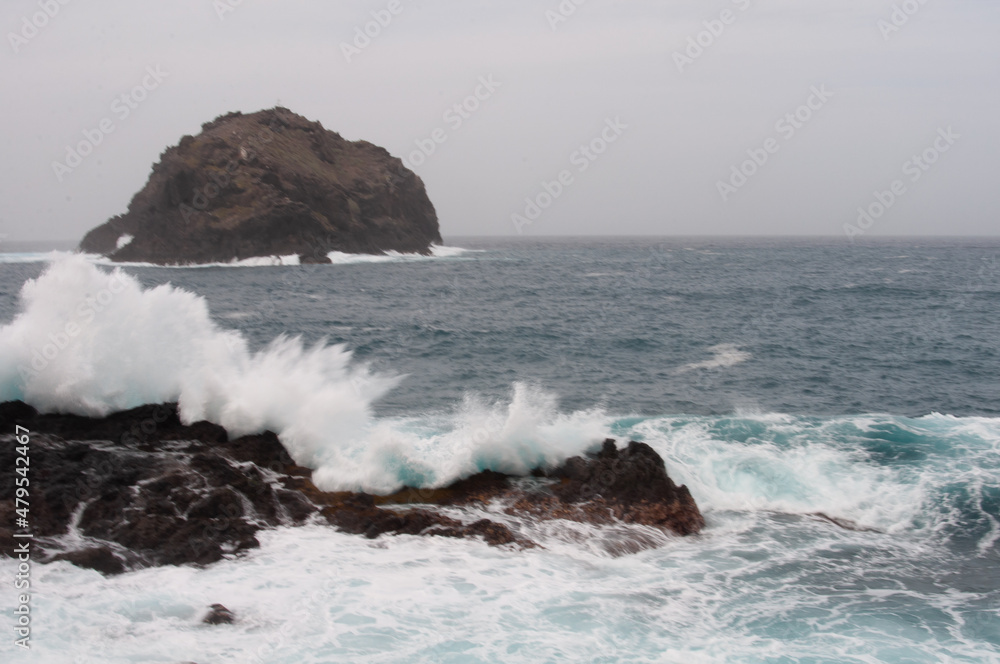the sea hits the rocks and the islet hard