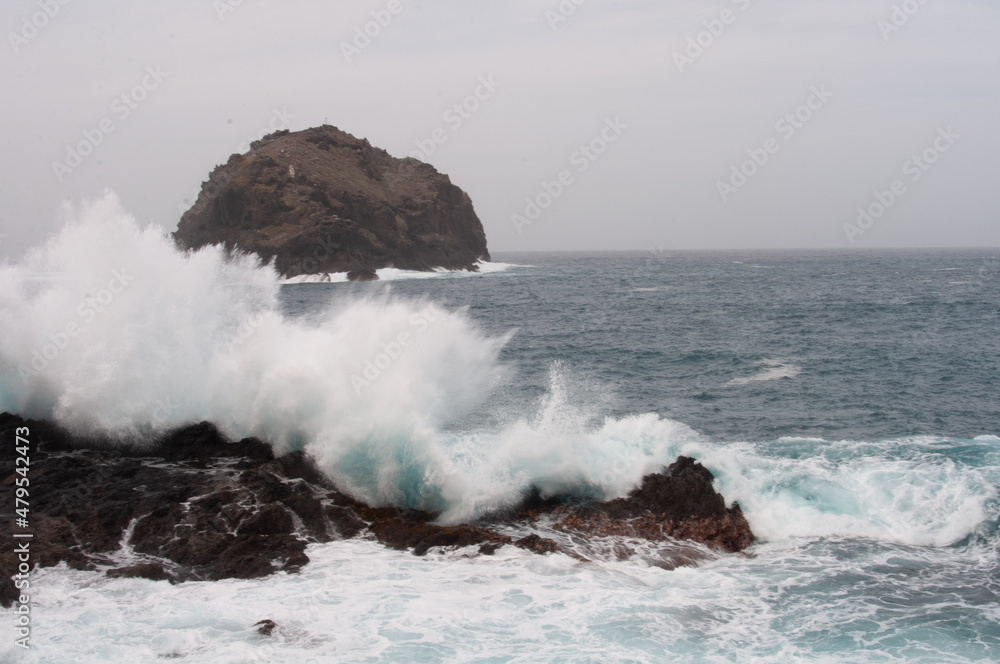 the sea hits the rocks and the islet hard