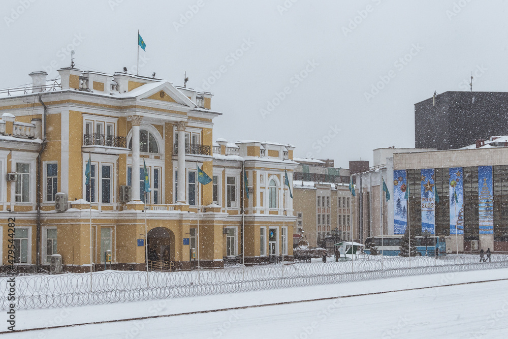 Naklejka premium Uralsk, Kazakhstan, 6.01.2022 - Barbed wire in front of the regional akimat, barbed wire around the perimeter of the state building during the state of emergency in the country, rallies in Kazakh