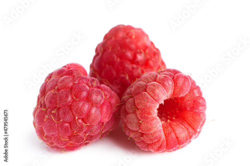 Three fresh red organic raspberries isolated on white background.