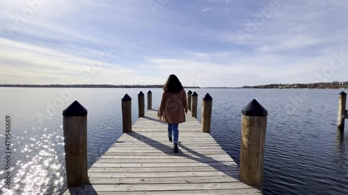 Girl walking on a boat launching deck at Mjnnetonka Lake during a sunny afternoon photo