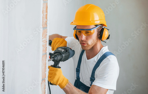 Portrait of young man working in uniform at construction at daytime