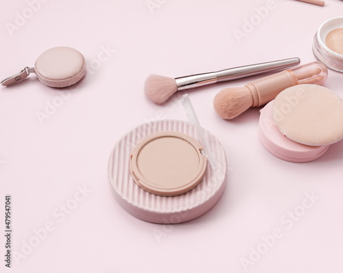Make up layout, accessories and face powder on pastel pink background. Minimal and luxury make up, cosmetic or beauty salon composition. Flat lay, top view, copy space.