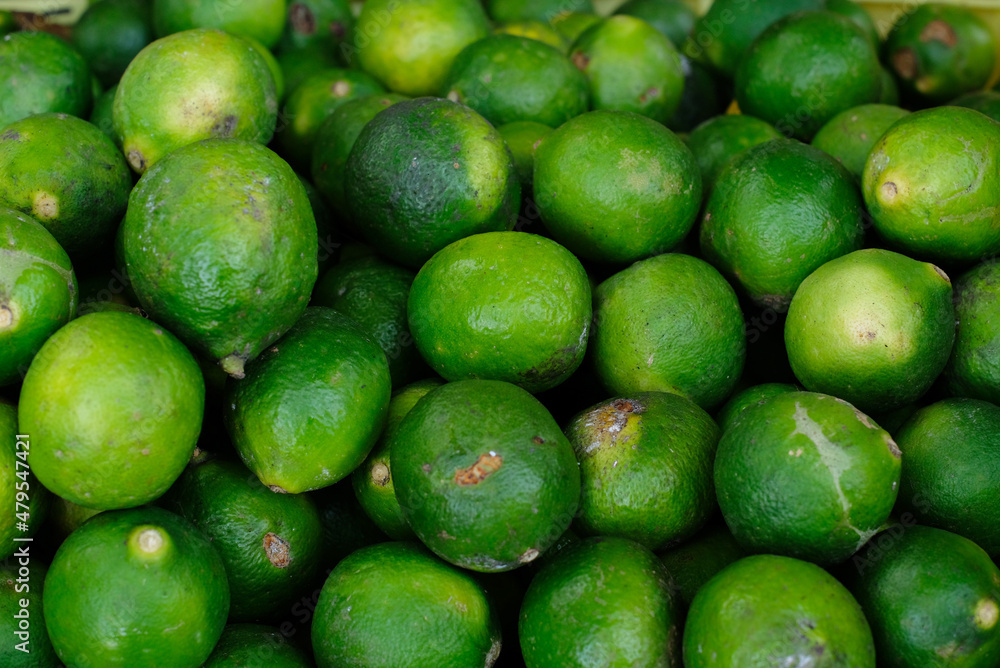 Fresh limes - Limes in bulk in the basket. Lime from the garden Fresh limes - Limes in bulk in the basket. Lime from the garden