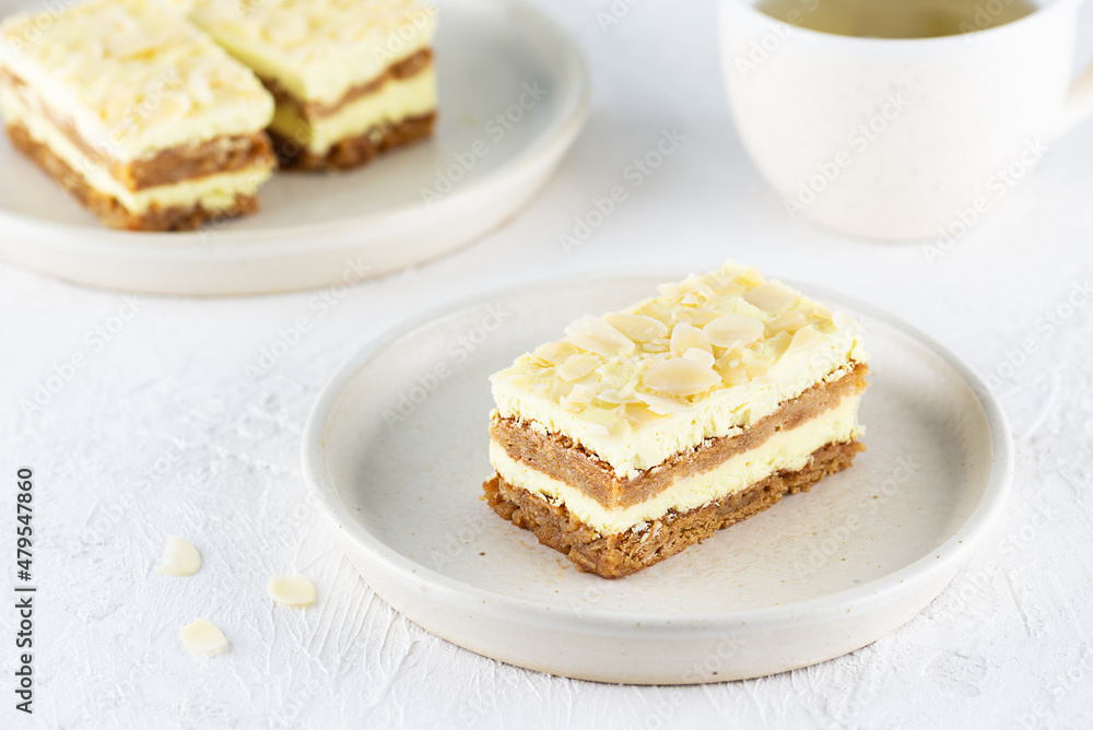 Portion of lemon cake with almonds in a plate with a cup of tea on the table. Sugar, gluten and lactose free and vegan. Portion of lemon cake with almonds in a plate with a cup of tea on the table. Sugar, gluten and lactose free and vegan.
