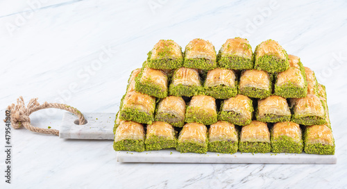 Turkish sweet Dry Baklava on a marble background. Turkish pastry dessert baklava. Ramadan or holiday desserts concept. Antep Baklavasi. local name; Kuru Baklava. photo