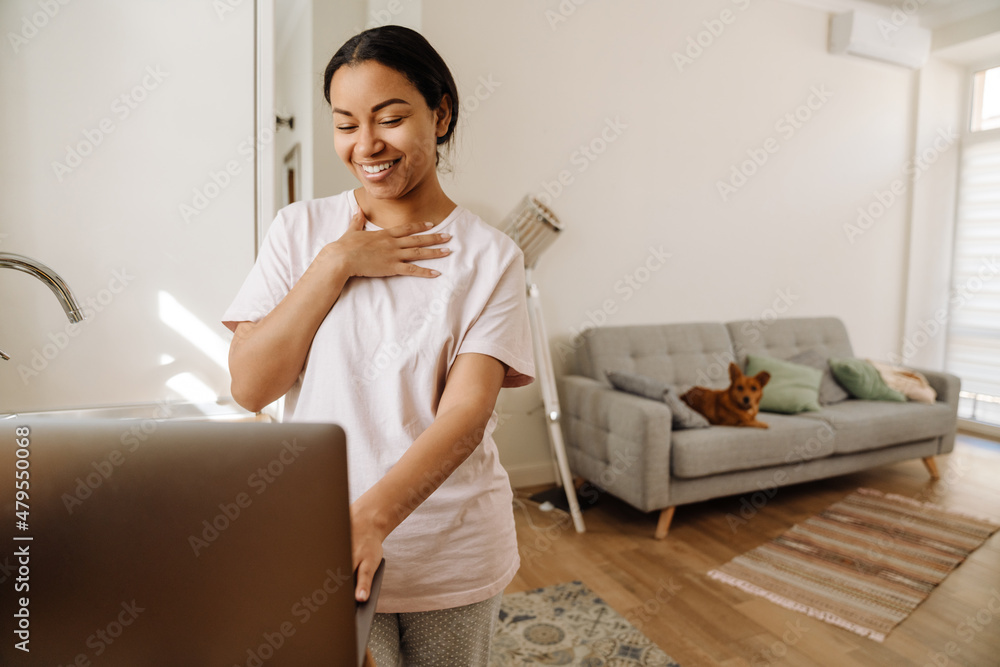 Young hispanic woman smiling and gesturing while using laptop Young hispanic woman smiling and gesturing while using laptop