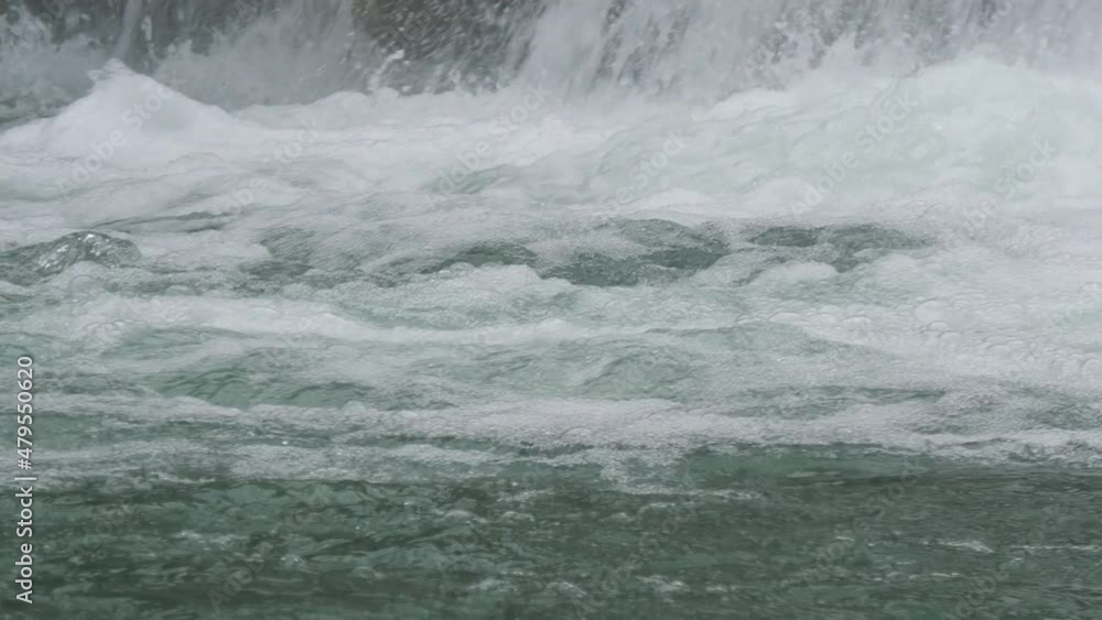 Foaming ripples from a waterfall flowing downstream, close up Foaming ripples from a waterfall flowing downstream, close up