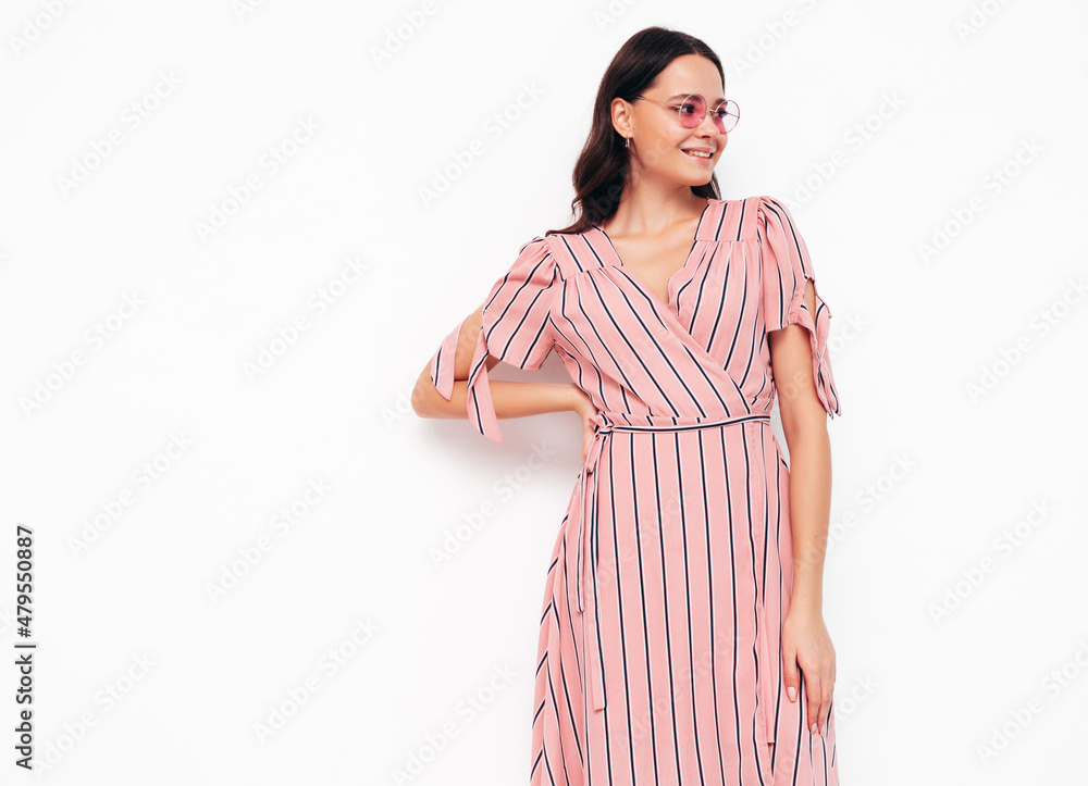 Portrait of young beautiful smiling female in trendy summer pink dress. Sexy carefree woman posing isolated on white in studio. Positive model having fun indoors. Cheerful and happy Portrait of young beautiful smiling female in trendy summer pink dress. Sexy carefree woman posing isolated on white in studio. Positive model having fun indoors. Cheerful and happy