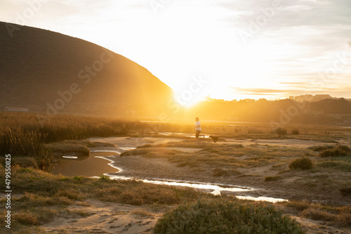 man playing with a small dog under suset light photo