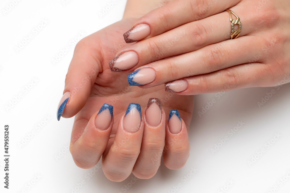 Sharp French manicure on long narrowed square nails with blue, brown, red sequins. Close-up on a white background. Sharp French manicure on long narrowed square nails with blue, brown, red sequins. Close-up on a white background.