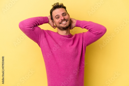 Young caucasian man isolated on yellow background stretching arms, relaxed position.