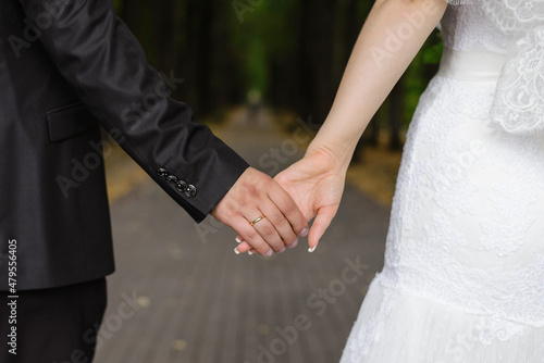A man holds a woman's hand. Hands of the bride and groom with a wedding ring close-up