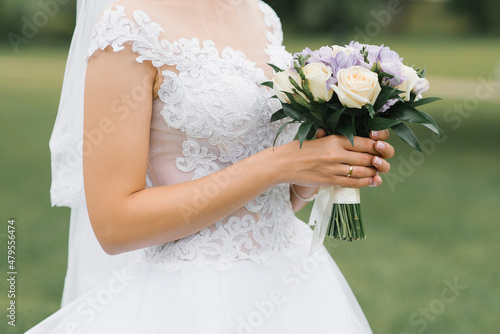 The bride's wedding bouquet of milk roses and lilac eustoms in the hands of the bride photo