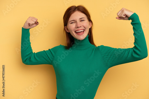 Young English woman isolated on yellow background showing strength gesture with arms, symbol of feminine power