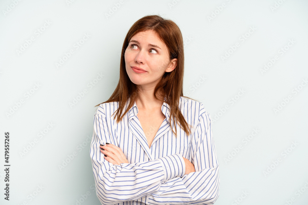 Young English woman isolated on blue background dreaming of achieving goals and purposes Young English woman isolated on blue background dreaming of achieving goals and purposes