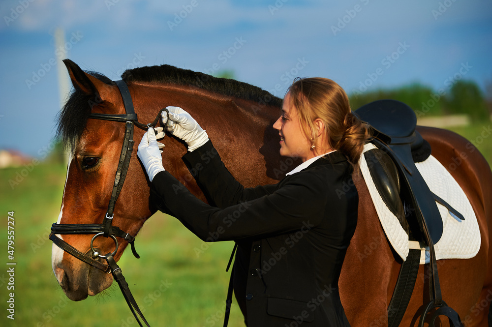 Beautiful horse rider girl stands near a horse on a farm
Beautiful horse rider girl stands near a horse on a farm