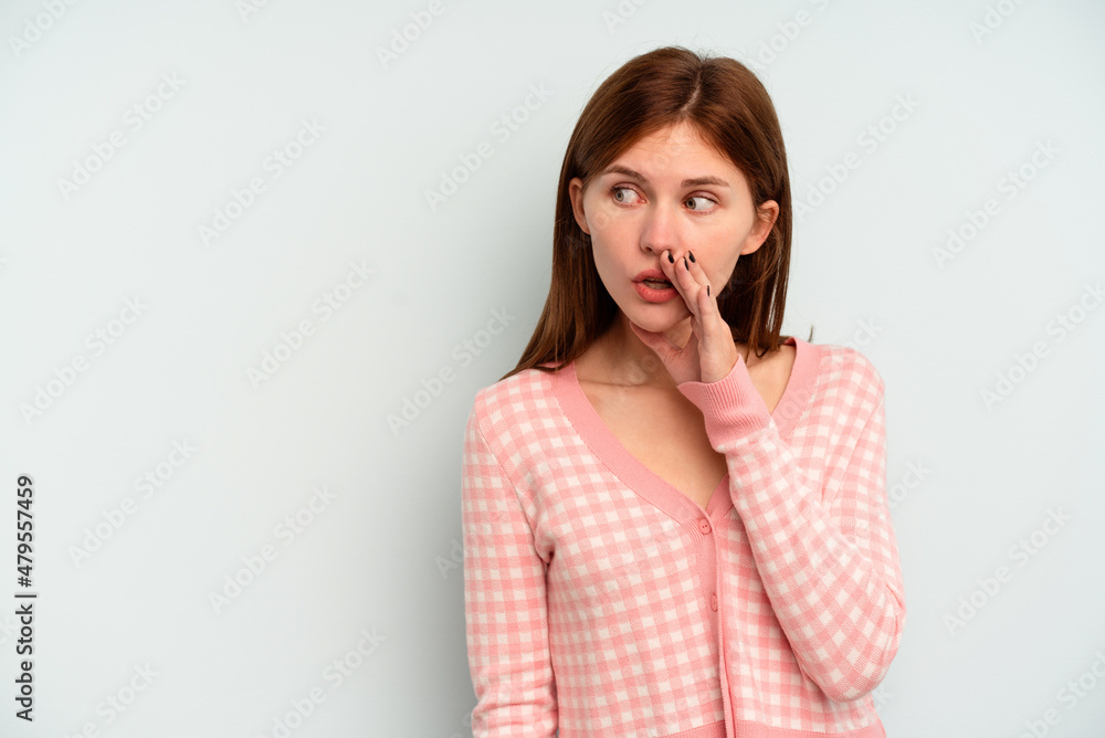 Young English woman isolated on blue background being shocked because of something she has seen. Young English woman isolated on blue background being shocked because of something she has seen.